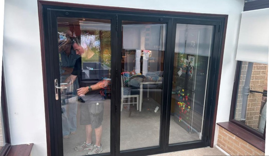 The new black three-pane bifold door in the same opening